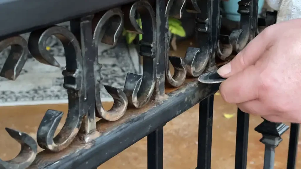 sanding rusted fence